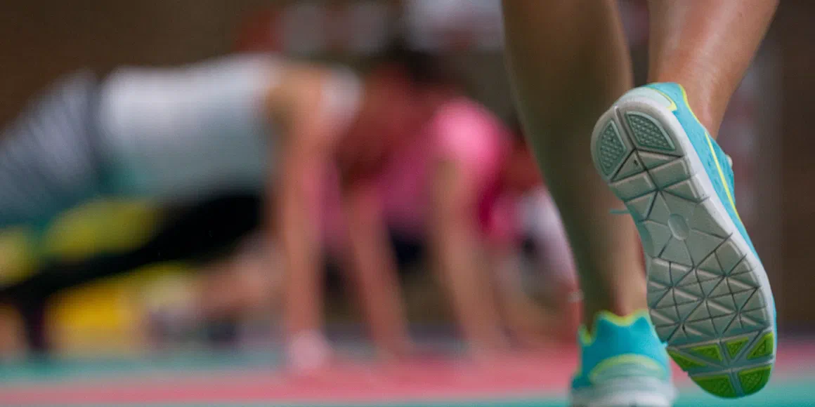 Sportowiec na bieżni stadionu, zbliżenie na buty